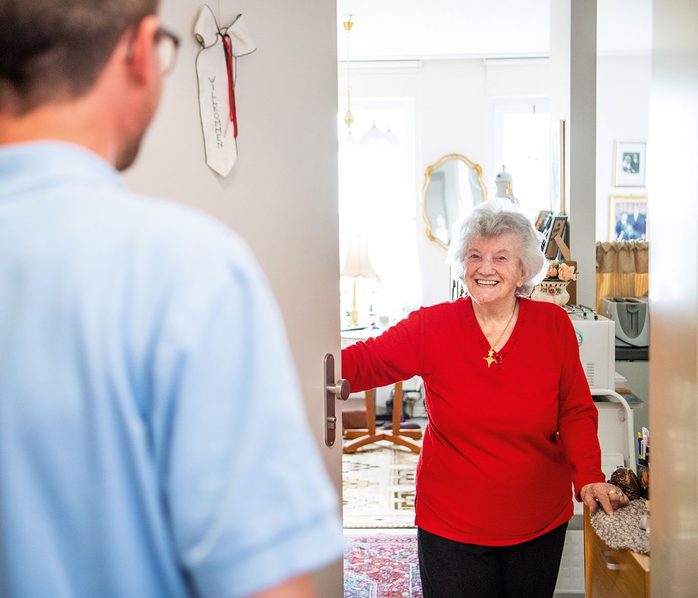 Pfleger einer ambulanten Pflege besucht eine Seniorin in ihrem Zuhause.
