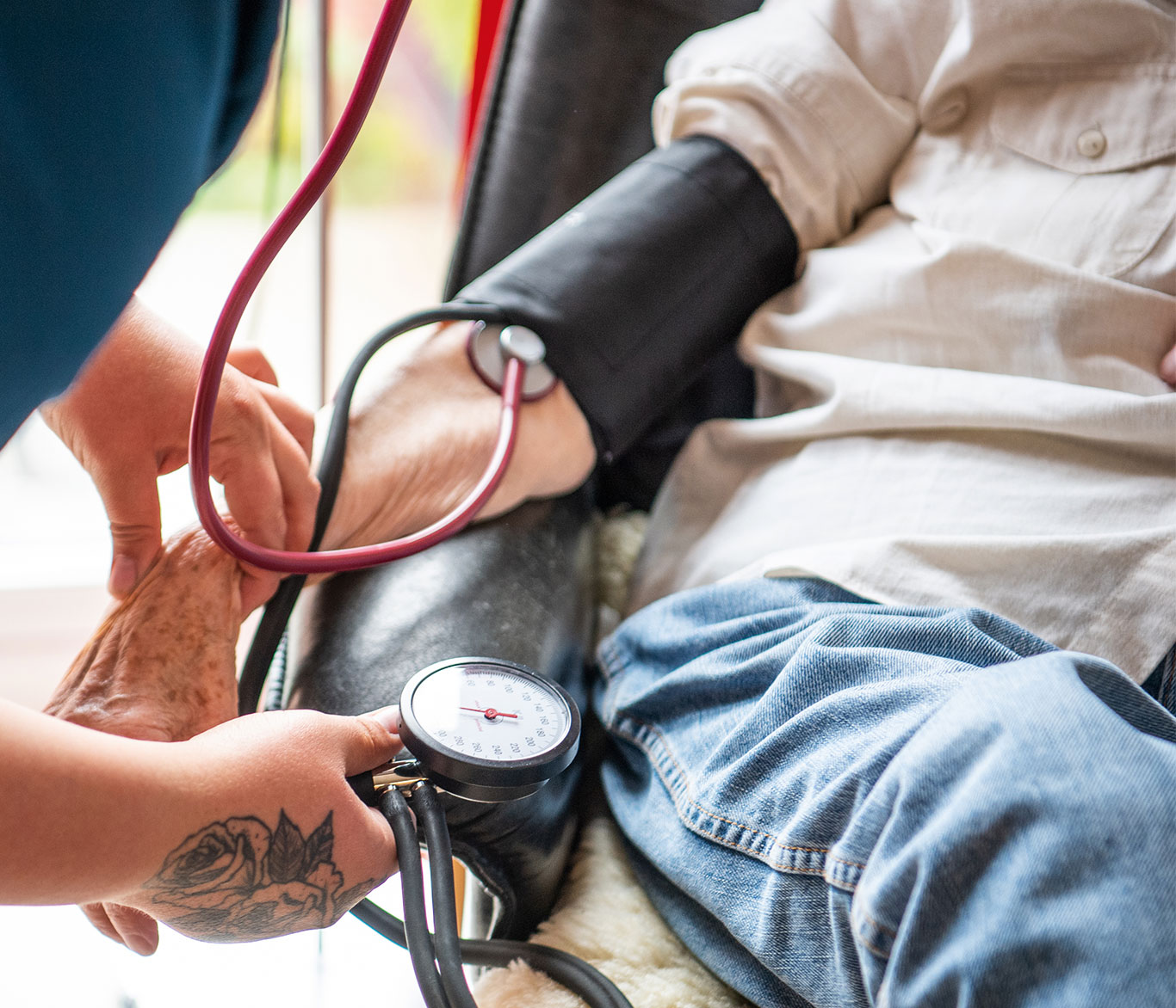 Eine Pflegerin misst den Blutdruck einer Pflegebedürftigen in der Seniorenpflege-Einrichtung Travetal.