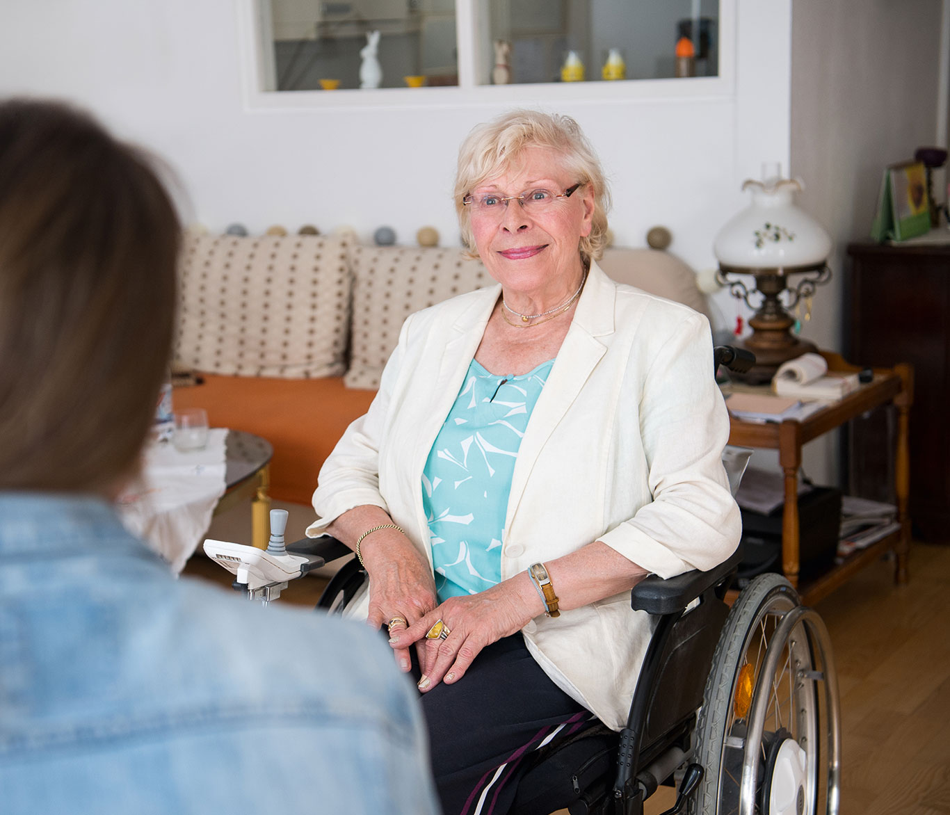Eine Seniorin im Rollstuhl unterhält sich in der betreuten Wohnanlage für Wohnen mit Service in Lübeck.