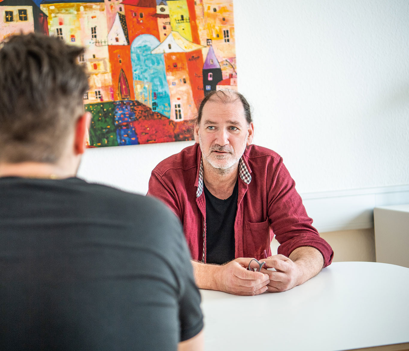 Ein Berater spricht mit einem jungen Menschen in der Beratungsstelle in Lübeck.