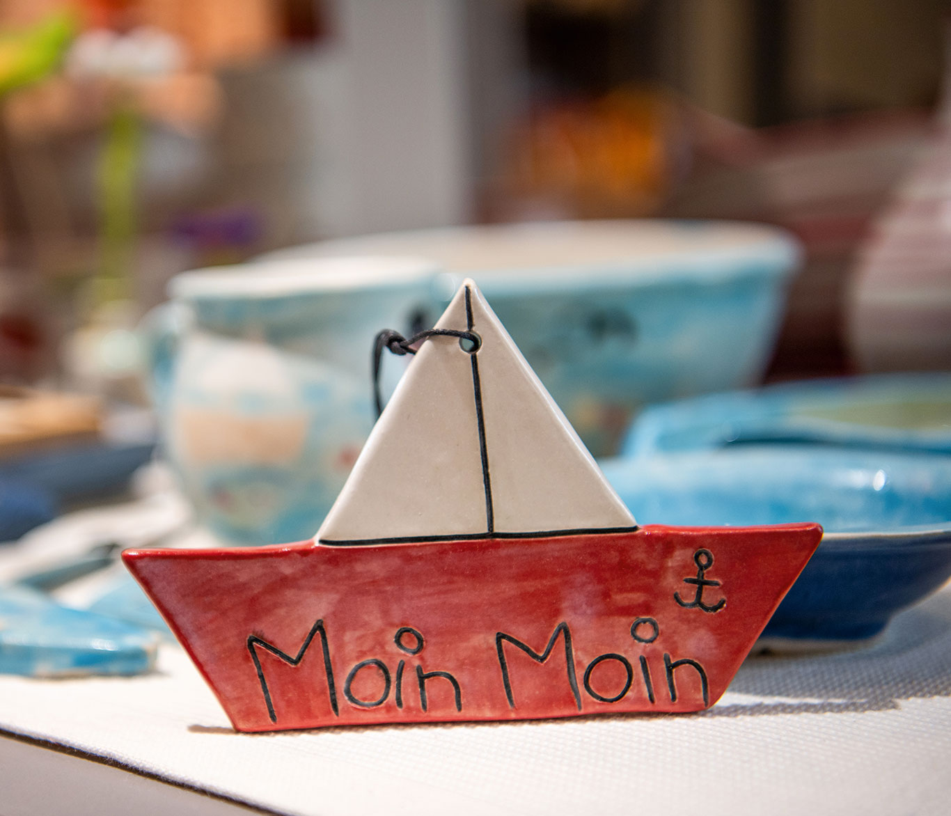 Ein getöpfertes Segelschiff mit der Aufschrift: Moin Moin.